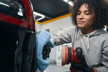 Experienced auto detailer polishing car by handの写真素材