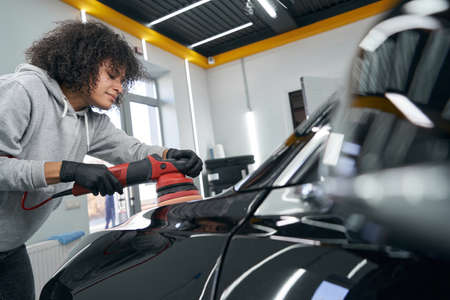 Focused calm car detailer polishing auto hoodの写真素材
