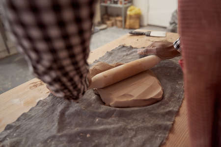 Potter working in studio at wedging table