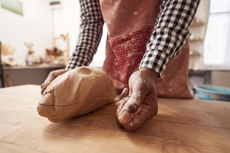 Experienced male ceramist using trimming pottery tool
