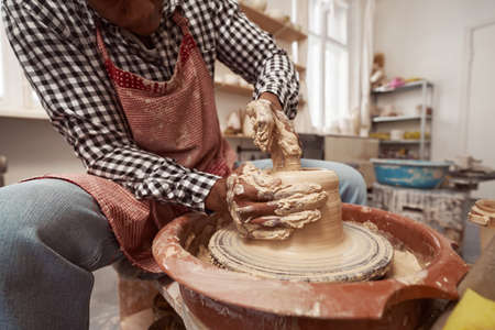 Experienced craft artist working on pottery wheel