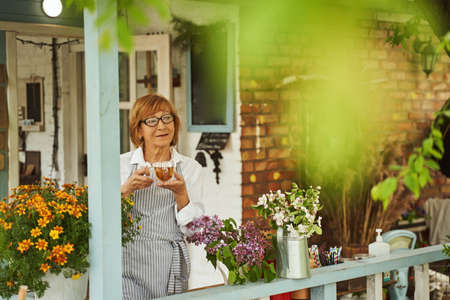 Pretty mature houswife drinking tea on terraceの写真素材