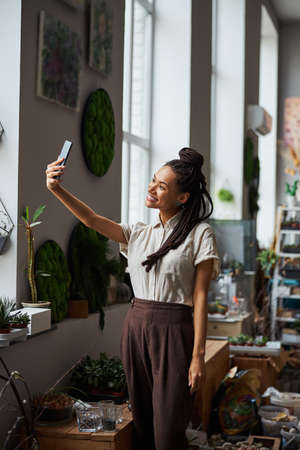 Smiling joyous floral designer taking a selfie