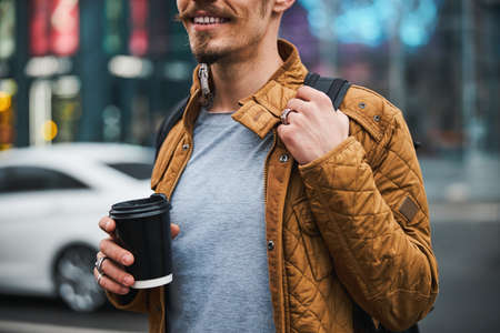 Smiling man drinking coffee in city centreの写真素材