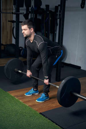 Man lifting barbell during weight workout in gym