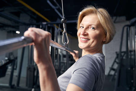 Cheerful woman doing strength workout in gymの写真素材