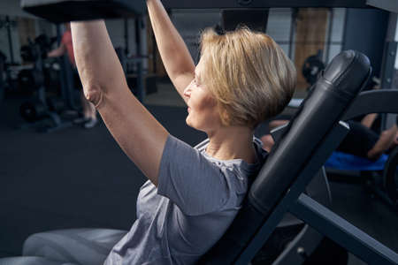 Blonde woman having workout in fitness club