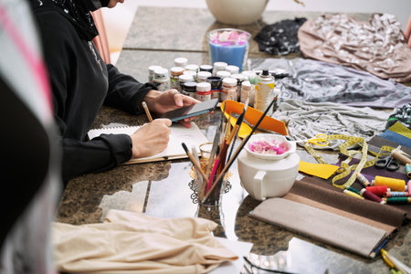 Creative muslim female making designer clothes in studio
