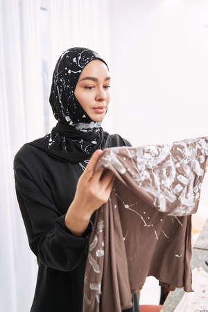 Young muslim woman estimating her handmade hijab