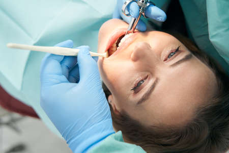 Woman receiving dental treatment in stomatology clinic