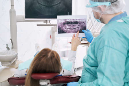 Woman discussing dental x-ray with dentist in stomatology clinicの写真素材