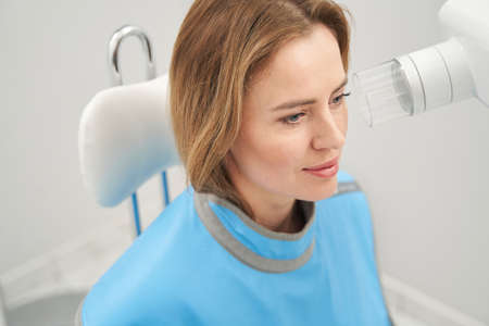 Woman sitting near dental equipment in clinic