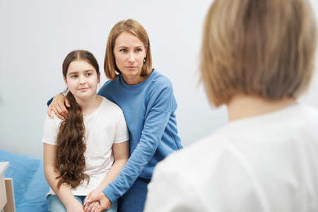 Woman and little girl having appointment with doctor in clinic