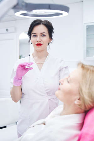 Pretty cosmetologist working in modern clinic of beautyの写真素材