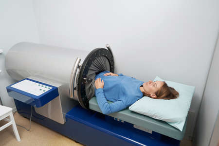 Female patient using vacuumed therapy equipment in clinic