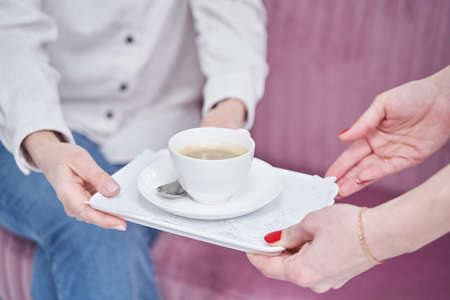 Close up of female hands holding cupの写真素材