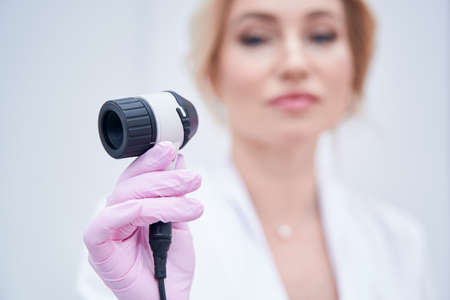 Experienced female dermatologist preparing for conducting dermatoscopyの写真素材