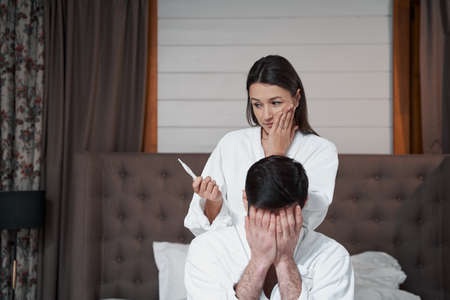 Female looking at her pregnancy test in surpriseの写真素材