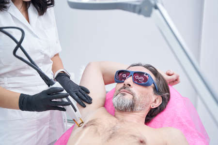 Adult male person visiting beauty clinic for doing procedure