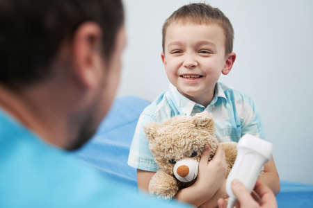 Joyful boy talking to the doctor in the officeの写真素材