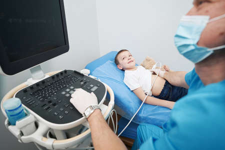 Caucasian young boy undergoing lung ultrasound at clinicの写真素材