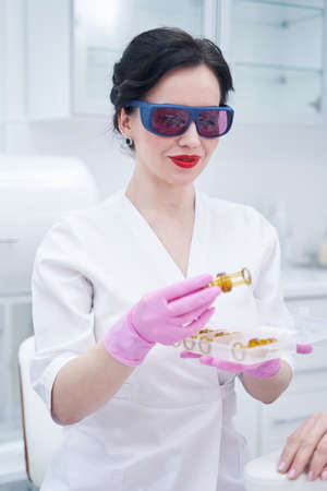 Female beautician holding parts of laser hair removal device