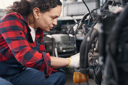 Concentrated female car mechanic fixing auto engineの写真素材
