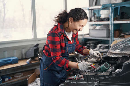 Delighted female mechanic working at service stationの写真素材