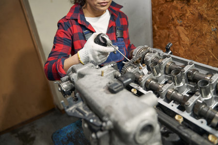 Female auto mechanic fixing car engine at service station