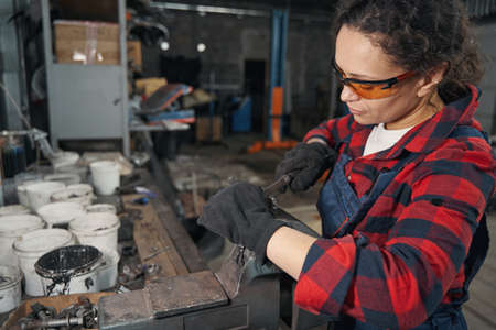 Woman auto mechanic working in car repair garage