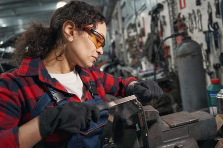 Female auto mechanic working in car repair garageの写真素材