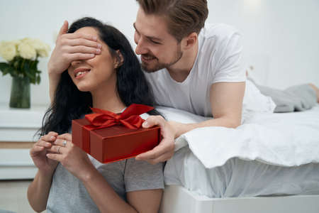 Loving man presenting gift to beloved womanの写真素材