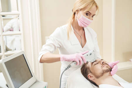 Beauty therapist taking care of sagging skin with SMAS facelift