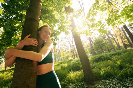 Smiling sporty woman enjoying solitude in natureの写真素材