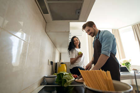 Happy lady watching her life partner cooking for herの写真素材