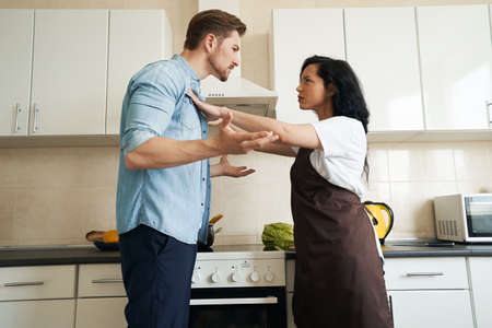 Woman and man having quarrel in kitchenの写真素材