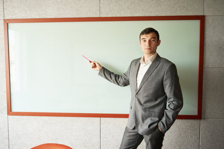 Man showing something on whiteboard with pencilの写真素材