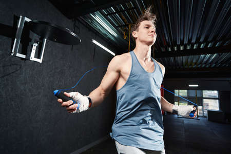 Strong well-built young man working out at gym
