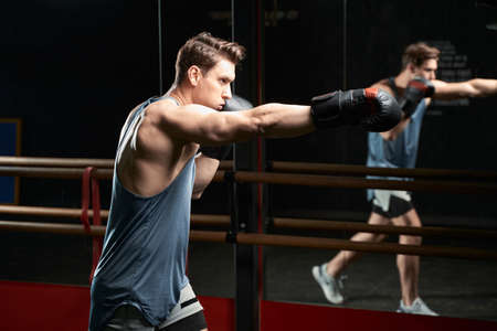 Determined sportsman practicing blows during gym workout