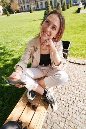 Lady is looking up holding her chin with her hand