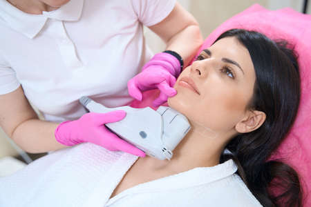 Patient undergoing an ultrasonic lifting procedure to tighten the skin on chinの写真素材