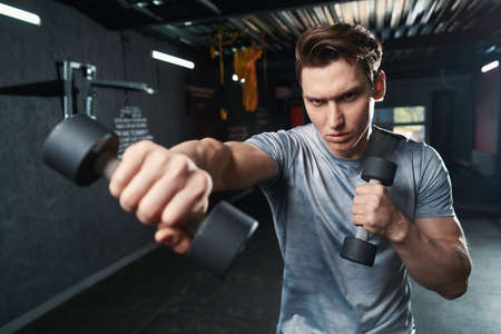 Professional sportsman practicing boxing moves with hand weightsの写真素材