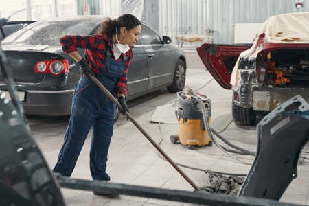 Concentrated mechanic cleaning workplace after car coloringの写真素材