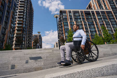 Disabled male person descending concrete staircase in business districtの写真素材