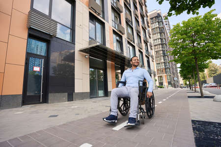 Young wheelchair-bound man looking around business districtの写真素材
