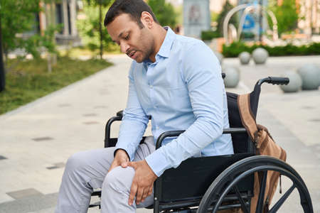 Disabled male person suffering from leg painの写真素材