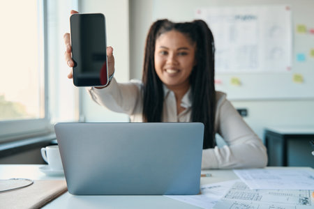 Female architect demonstrating her smartphone before cameraの写真素材