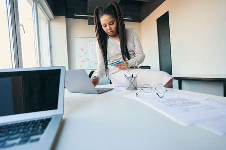 Concentrated female office worker making online order