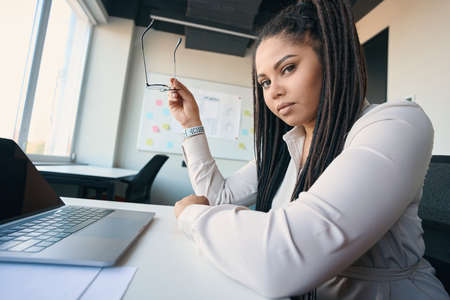 Tranquil female office worker seated in workplaceの写真素材