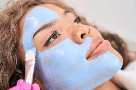 Young woman on face cleaning procedure in cosmetology clinic